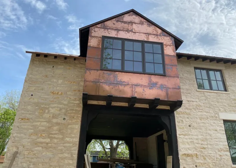 Copper metal panel facade on a stone building for Roof Repair in Vista